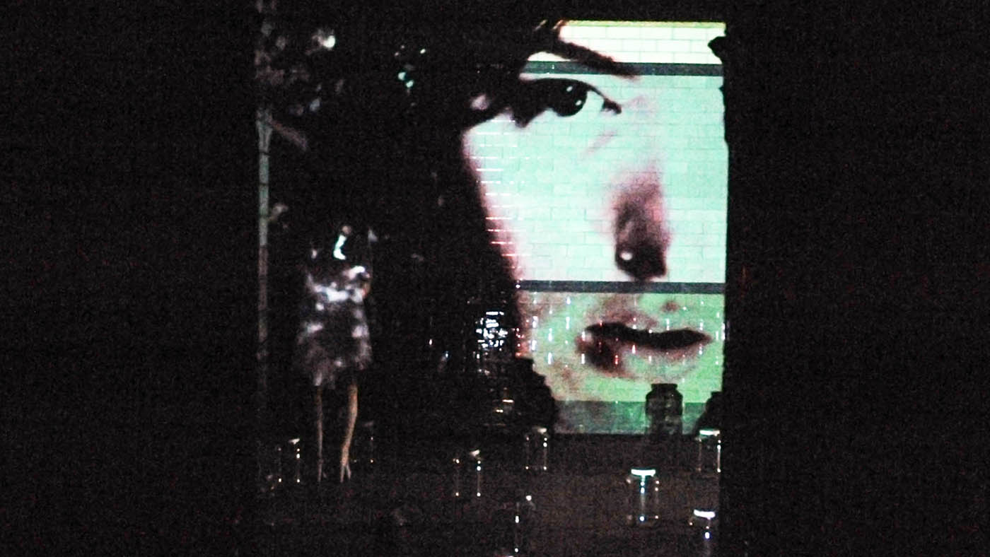 Pickle jars: Projection of face through pickle jars onto the tiled wall. Dancer walks through projection to place shoes in jars.